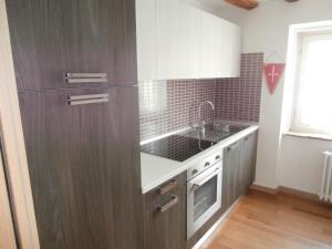 a kitchen with wooden cabinets and a sink at Torretta International in Trieste