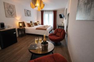 a hotel room with a bed and a table with wine glasses at Logis Hôtel Blue Garden in Grandvillers +53 photos