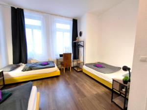 a room with two beds and a desk and a window at Schwert City Loft S41 2 BAD 2 WC 4 Schlafzimmer in Verden
