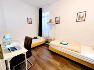 a room with two beds and a desk with a laptop at Schwert City Loft S41 2 BAD 2 WC 4 Schlafzimmer in Verden +5 photos