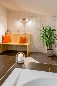 a room with a bench with orange pillows and a candle at Appartement Stuibenfallblick in Umhausen +25 photos