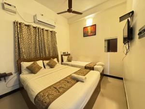 a hotel room with two beds and a tv at La Paradise Residency - TIE Hotels in Pondicherry