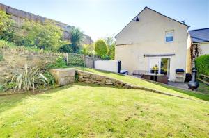 a yard with a stone wall and a house at 3 Bed in Croyde oc-yellow in Croyde
