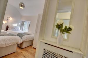 a room with two beds and a vase with flowers in it at 3 Bed in Croyde oc-yellow in Croyde