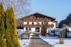 a house with a car parked in the snow at Camping Seehof in Kramsach +6 photos