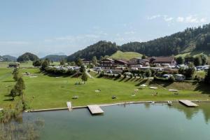 a view of a resort with a lake and houses at Camping Seehof in Kramsach