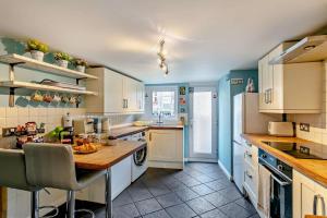 a kitchen with white cabinets and a table in it at 3 Bed in Dawlish oc-c29669 in Dawlish +20 photos