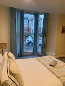 a bedroom with a bed and a large window at 36 flat 1 - Room 1 in Swansea