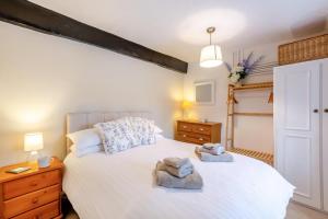 a bedroom with a white bed with towels on it at 4 Bed in Satterthwaite oc-c32334 in Grizedale