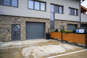 a parking lot in front of a building with a garage at Birdhouse in Prešov