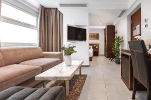 a living room with a couch and a tv at Achilleos City Hotel in Larnaca