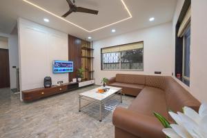 a living room with a couch and a tv at Vrundavan Villa Lonavala in Malavli