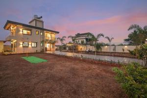 a large house with a green lawn in front of it at Vrundavan Villa Lonavala in Malavli