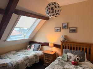 a childs bedroom with two beds and a window at Old Barn, Beach Farm Hunstanton - Dog Friendly in Heacham
