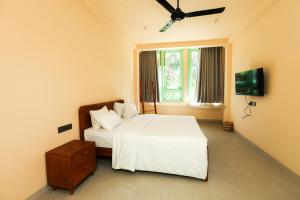 a bedroom with a white bed and a window at Allude Villa Weligama in Weligama