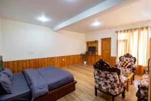a bedroom with a bed and a couch and a chair at Manali Parvat View in Jagatsukh