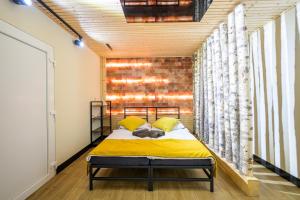 a bedroom with a bed and a brick wall at Birdhouse in Prešov
