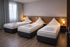 ein Hotelzimmer mit zwei Betten und zwei Lampen in der Unterkunft Hotel M in Nürnberg + 2 Fotos