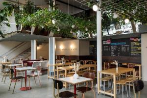 a restaurant with tables and chairs and plants at People Lyon Hotel in Lyon