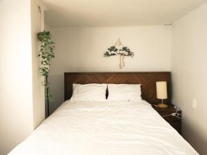 a bedroom with a white bed with areath on the wall at Bandal Stay in Daegu in Daegu