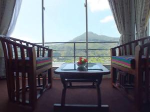 a room with a table and two chairs and a window at Mount view cottage in Nuwara Eliya