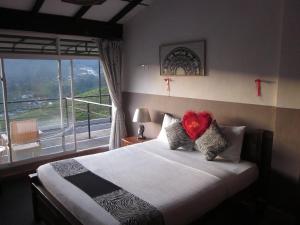 a bedroom with a bed with a heart pillow on it at Mount view cottage in Nuwara Eliya