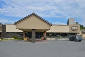 a building with a car parked in a parking lot at Rodeway Inn in Sudbury