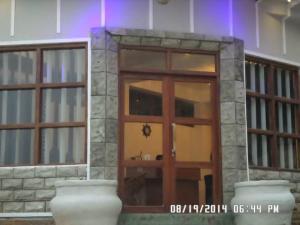 a large glass door in a building with two vases at Mount view cottage in Nuwara Eliya
