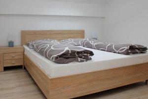 un letto con testiera in legno e comodino in legno di Penzion Réva a Jablunkov