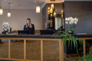 a woman standing at a counter in a salon at Hampshire Court Hotel & Spa in Basingstoke
