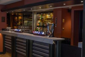 a bar with a lot of bottles of alcohol at Hampshire Court Hotel & Spa in Basingstoke +34 photos