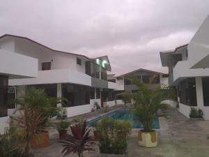 Un edificio de apartamentos con piscina y palmeras. en Casa en Tonsupa, en Tonsupa