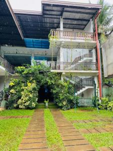 a building with a walkway in front of a yard at Nimjaya holiday bunglow in Anuradhapura