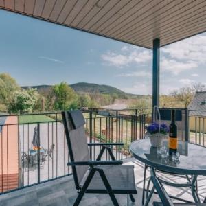 a patio with a table and a bottle of wine at Békeapartmanház in Badacsonytomaj