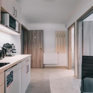 a kitchen with white counter tops and a kitchen sidx sidx sidx at Békeapartmanház in Badacsonytomaj