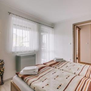 a bedroom with a bed with a window and a window at Békeapartmanház in Badacsonytomaj