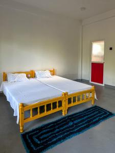 a yellow bed in a room with a rug at Vibra Hostel in Sigiriya