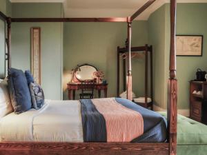 a bedroom with a canopy bed and a mirror at Sancreed House B&B in Penzance