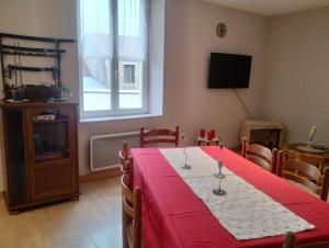 a dining room with a table with a red table cloth at En passant par La Maraude in Vigneulles-lès-Hattonchâtel