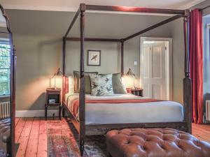 a bedroom with a canopy bed and two lamps at Sancreed House B&B in Penzance +48 photos