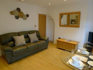 a living room with a leather couch and a glass table at Church Court Apartments in Rugby