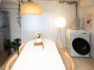a dining room with a table and a washing machine at Bandal Stay in Daegu in Daegu