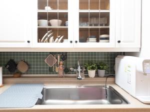 a kitchen with white cabinets and a sink at Bandal Stay in Daegu in Daegu +21 photos