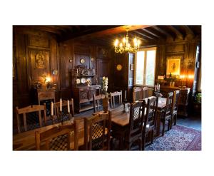 a dining room with a table and chairs and a chandelier at Le Bailli de Montsaugeon in Montsaugeon