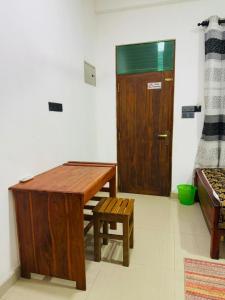 a room with a wooden table and a door at Nimjaya holiday bunglow in Anuradhapura