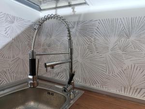 a kitchen sink with a faucet on a wall at Altea - Lago di Como nuovo accogliente mini appartamento vicino alla spiaggia e giardino in Dervio +76 photos