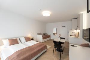 a white bedroom with a bed and a desk at Studio 4 in Bad Schallerbach