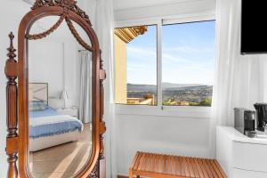 a bedroom with a mirror and a bed and a window at Montaña Mimosa B&B in Alhaurín el Grande +43 photos