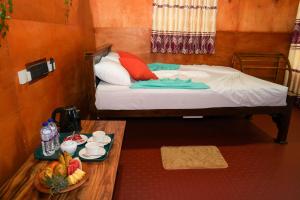 a room with a bed and a table with a tray of fruit at Comfort Treehouse Pidurangala in Dambulla