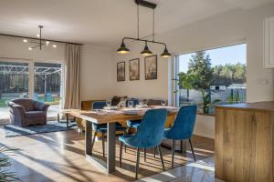 a dining room with a wooden table and blue chairs at Agroturystyka Milówka in Jagodzin
